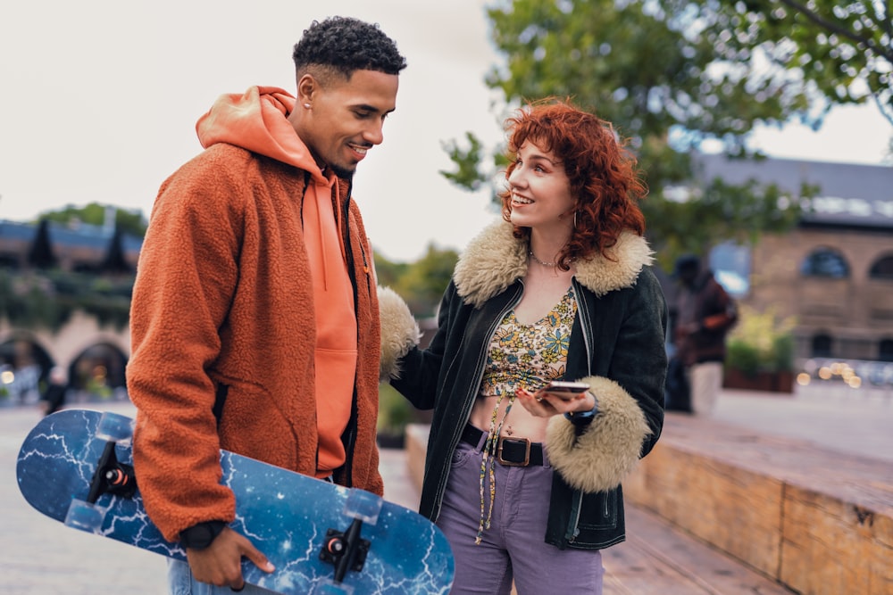 a man and woman holding a skateboard