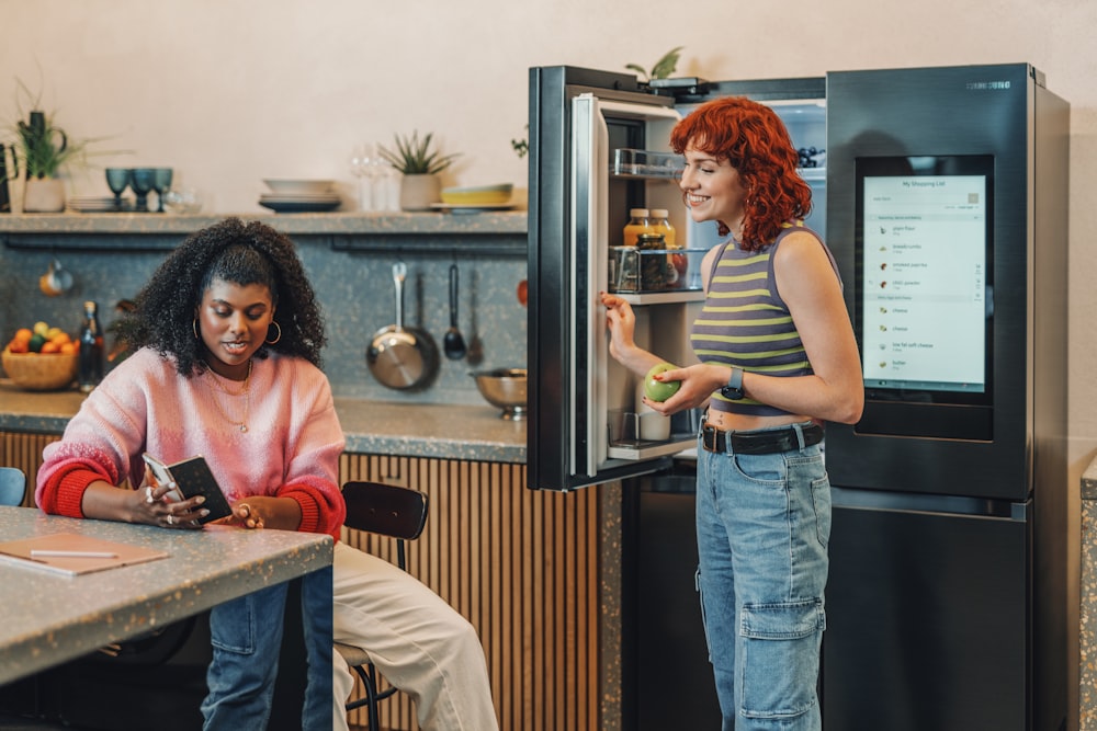 a person standing next to a person sitting at a table