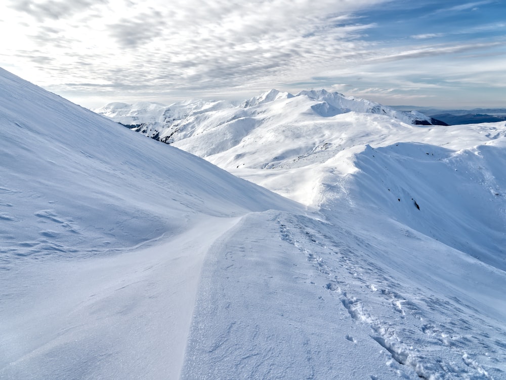 a snowy mountain with a trail