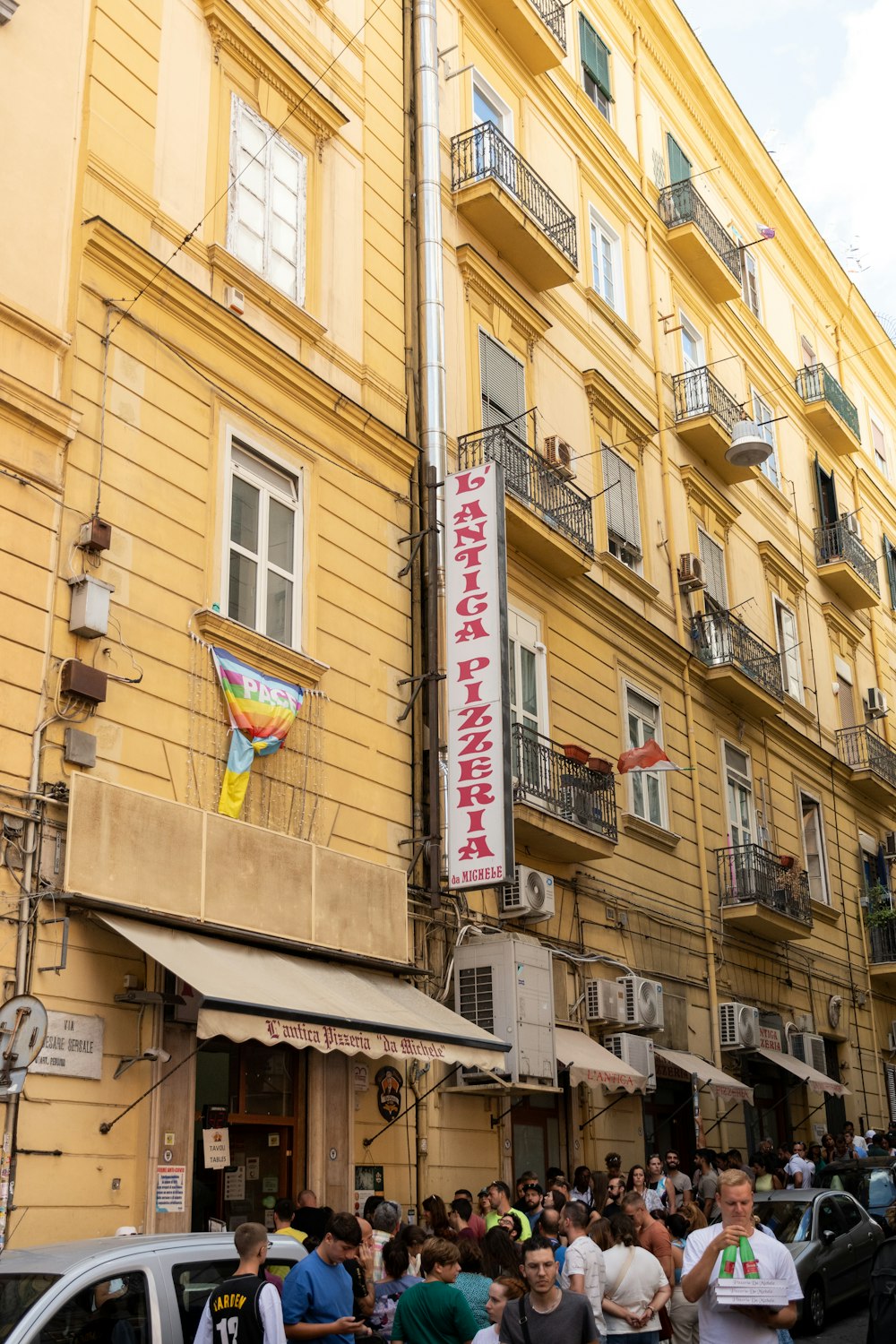 a crowd of people walking on a street between buildings