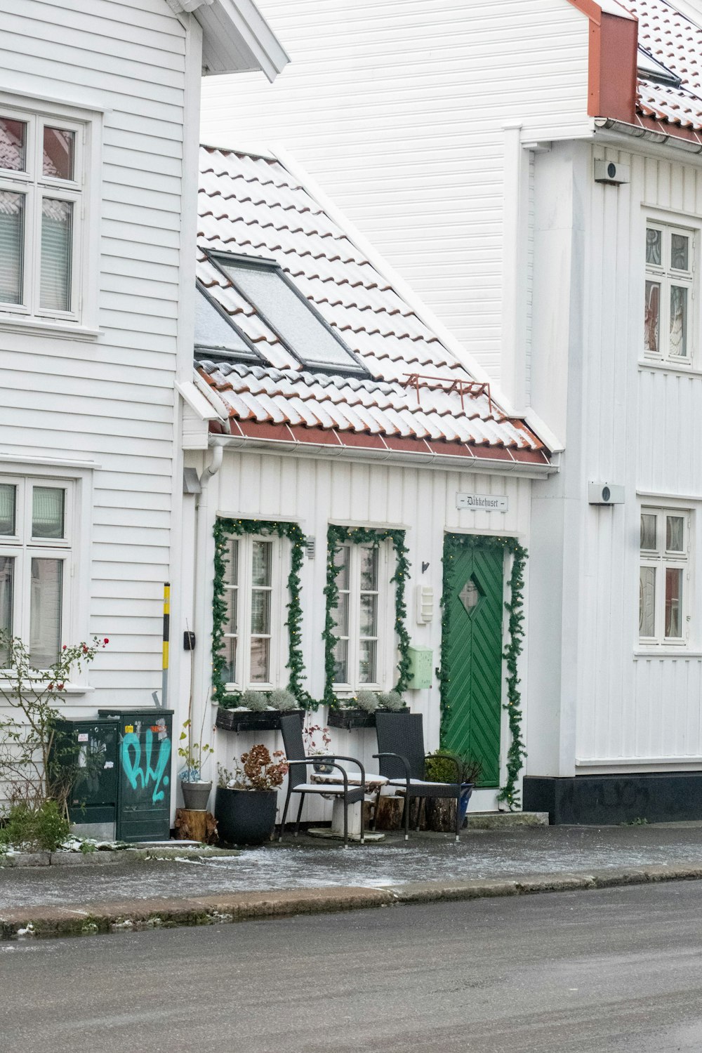Ein weißes Haus mit grünen Türen