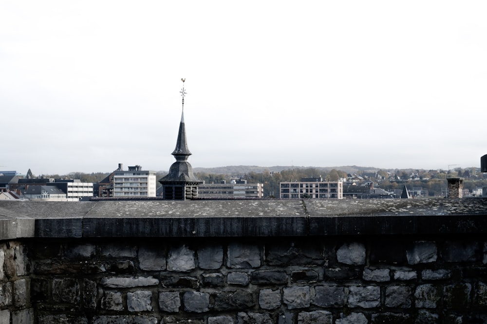 a stone wall with a tower in the background