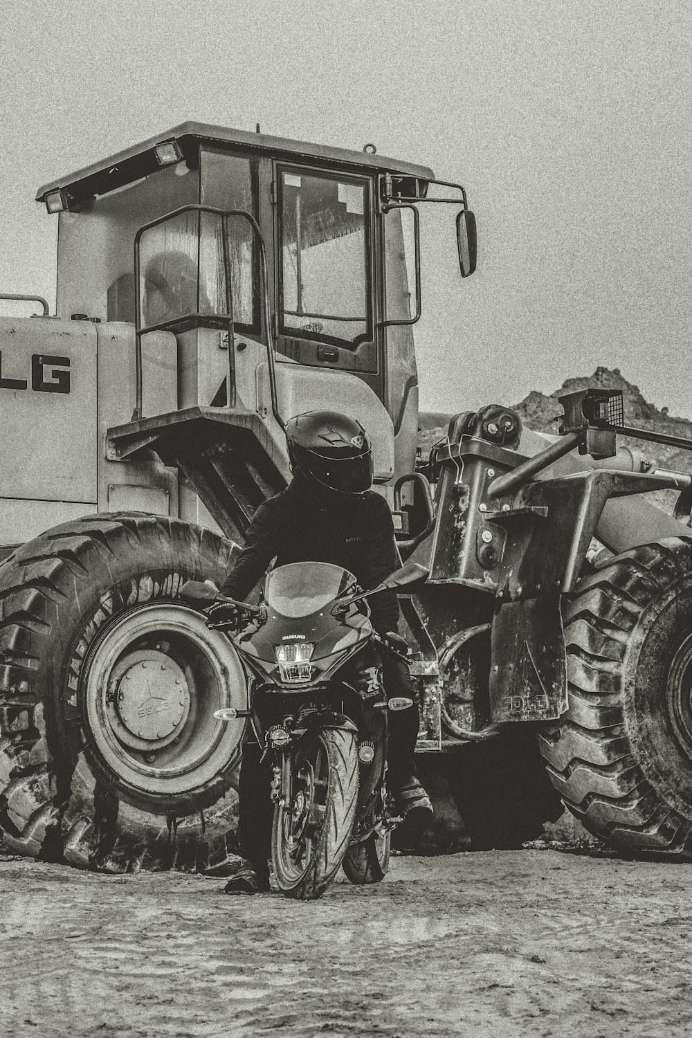 a person on a motorcycle next to a tractor