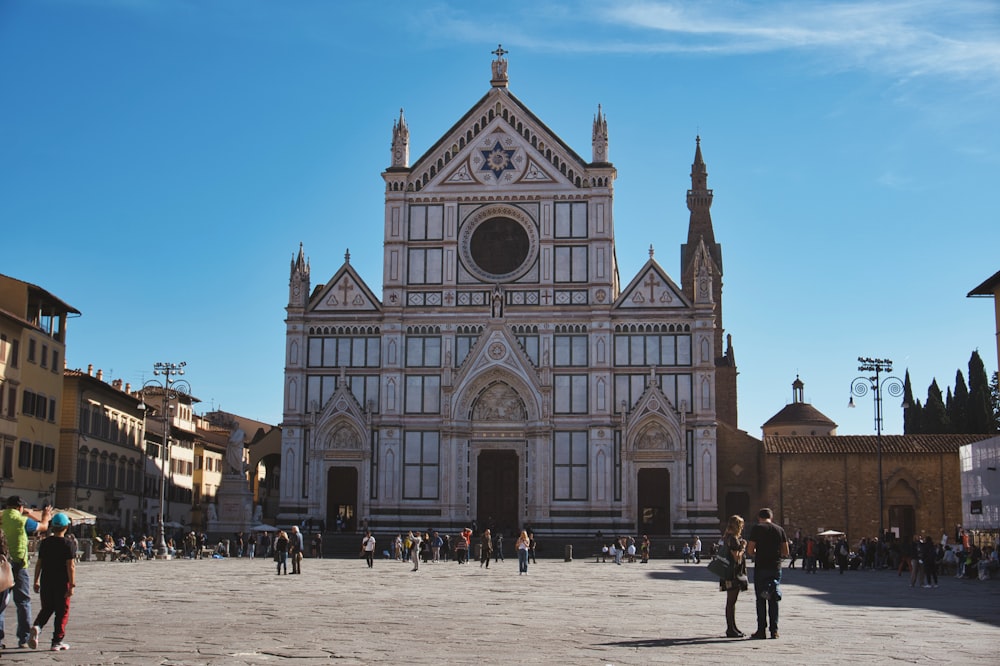 a large building with people walking around with Santa Croce, Florence in the background