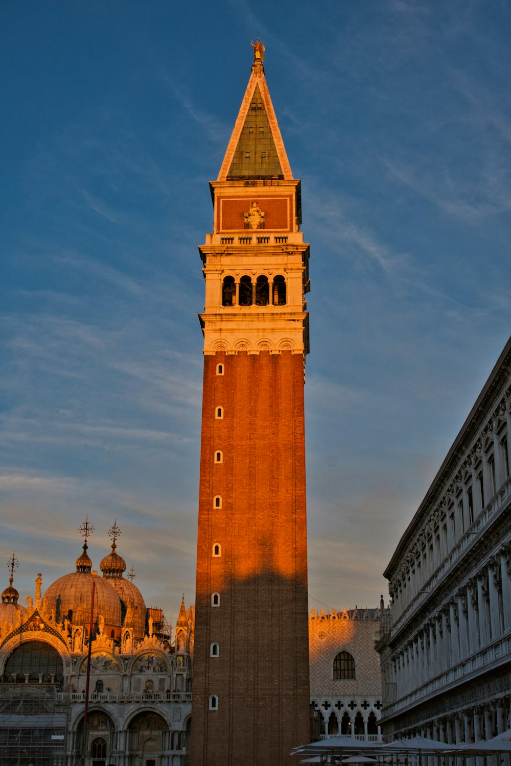 a tall building with a gold roof with St Mark's Campanile in the background