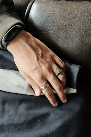 Close-up of leather cuffs resting on a black velvet surface, hinting at restraint and power.