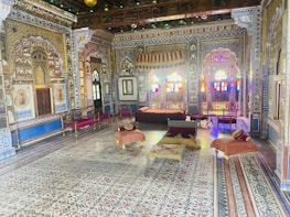 Elegant Saudi-style majlis with rich fabrics and traditional patterns in a cozy setting