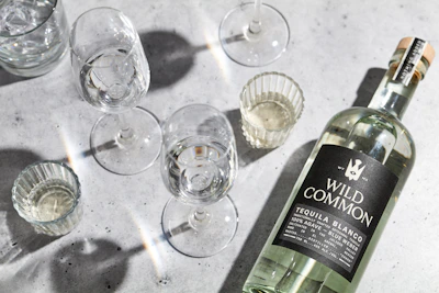 a bottle of wine next to several empty wine glasses