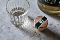 a glass of water next to a bottle of alcohol