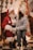 A joyful child sitting on Santa Claus's lap during a cozy home visit.