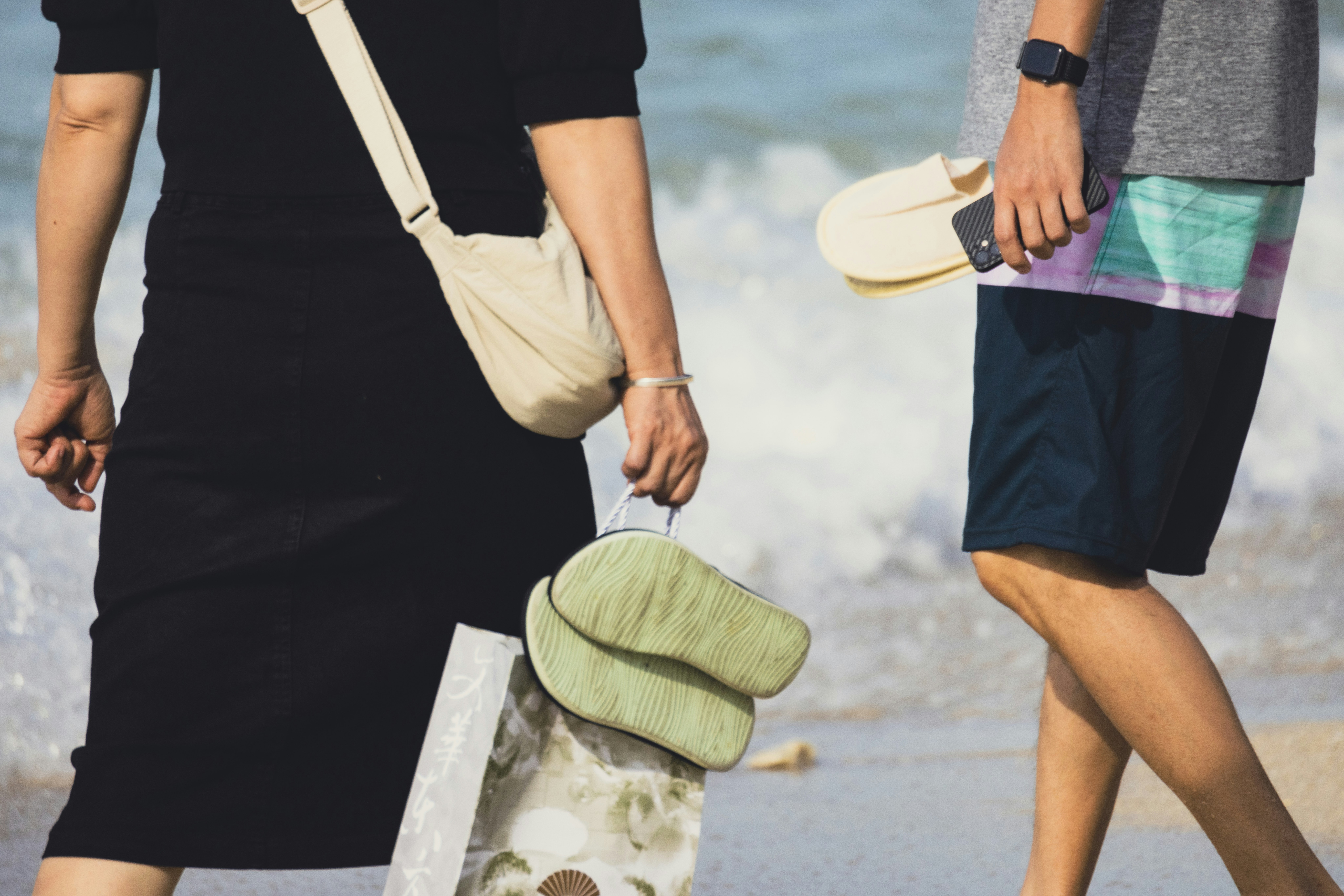 a couple of people walking on the beach