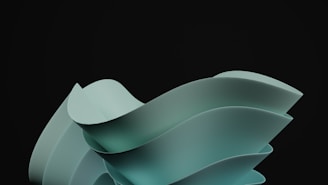 A sleek and modern abstract sculpture with smooth, flowing curves set against a dark background. The sculpture appears to consist of overlapping, ribbon-like structures in a muted teal color, creating a sense of movement and fluidity.