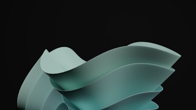 A sleek and modern abstract sculpture with smooth, flowing curves set against a dark background. The sculpture appears to consist of overlapping, ribbon-like structures in a muted teal color, creating a sense of movement and fluidity.