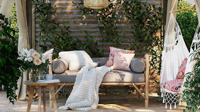 A cozy outdoor nook featuring a wooden loveseat adorned with soft cushions and a woven decorative basket beside it.