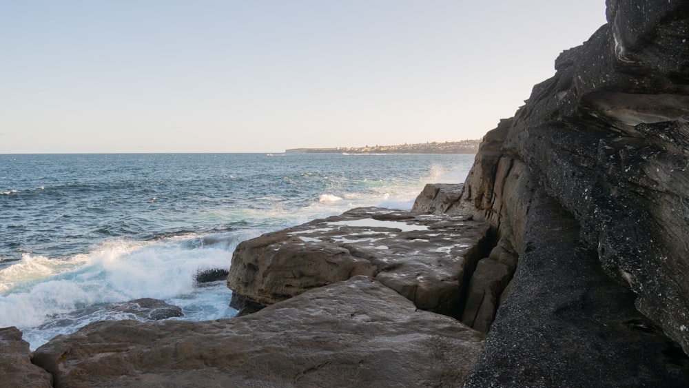 a rocky beach with waves crashing against it