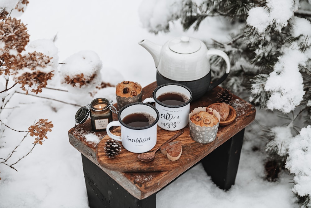 a tray with coffee and teapots on it in the snow