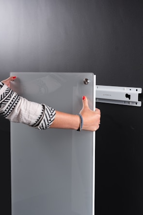 A handyman carefully mounting a flat screen TV on a wall bracket.
