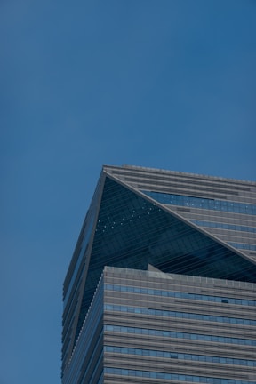 Modern high-rise office building set against a clear blue sky, showcasing structural engineering precision.