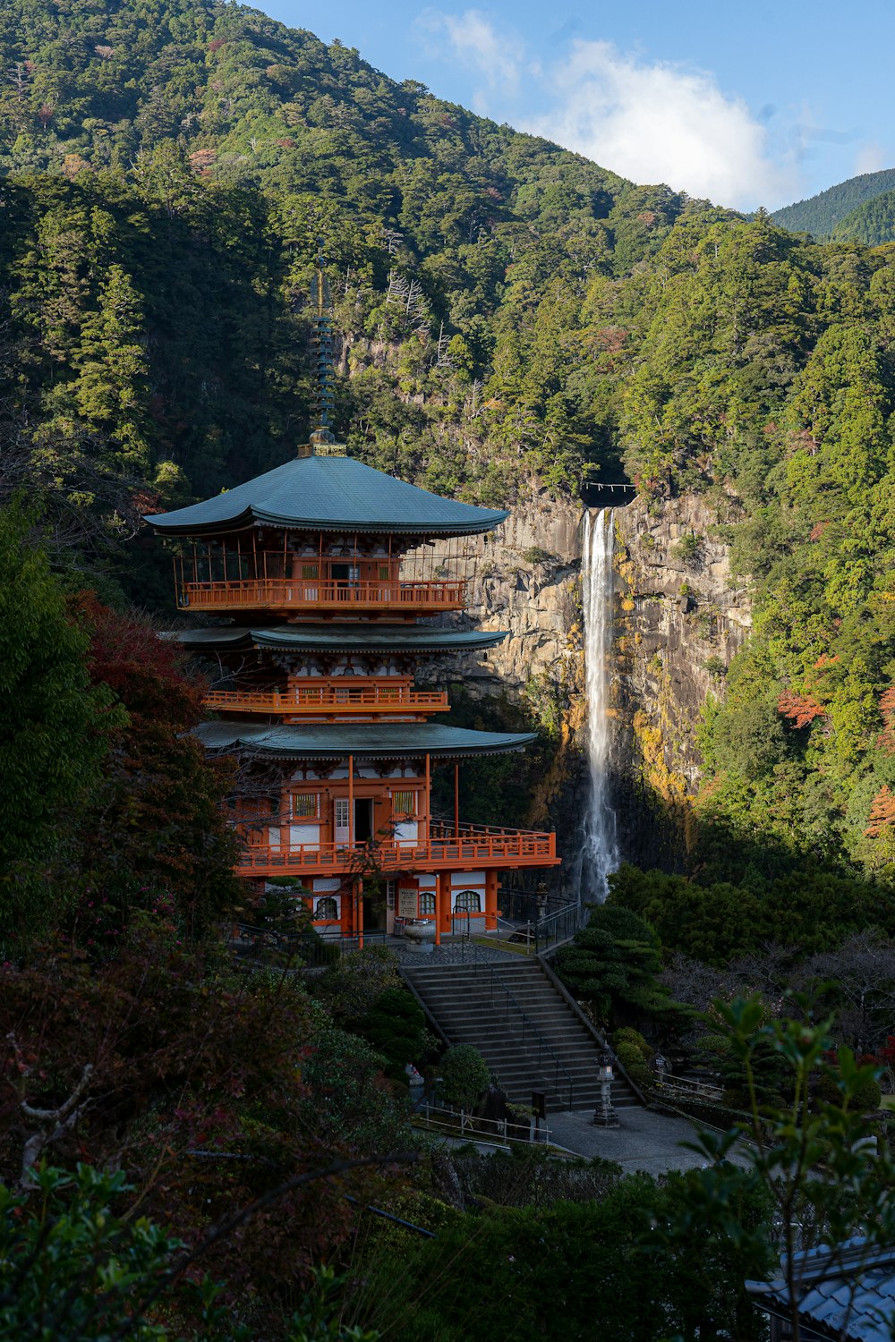 a building with a waterfall and trees around it