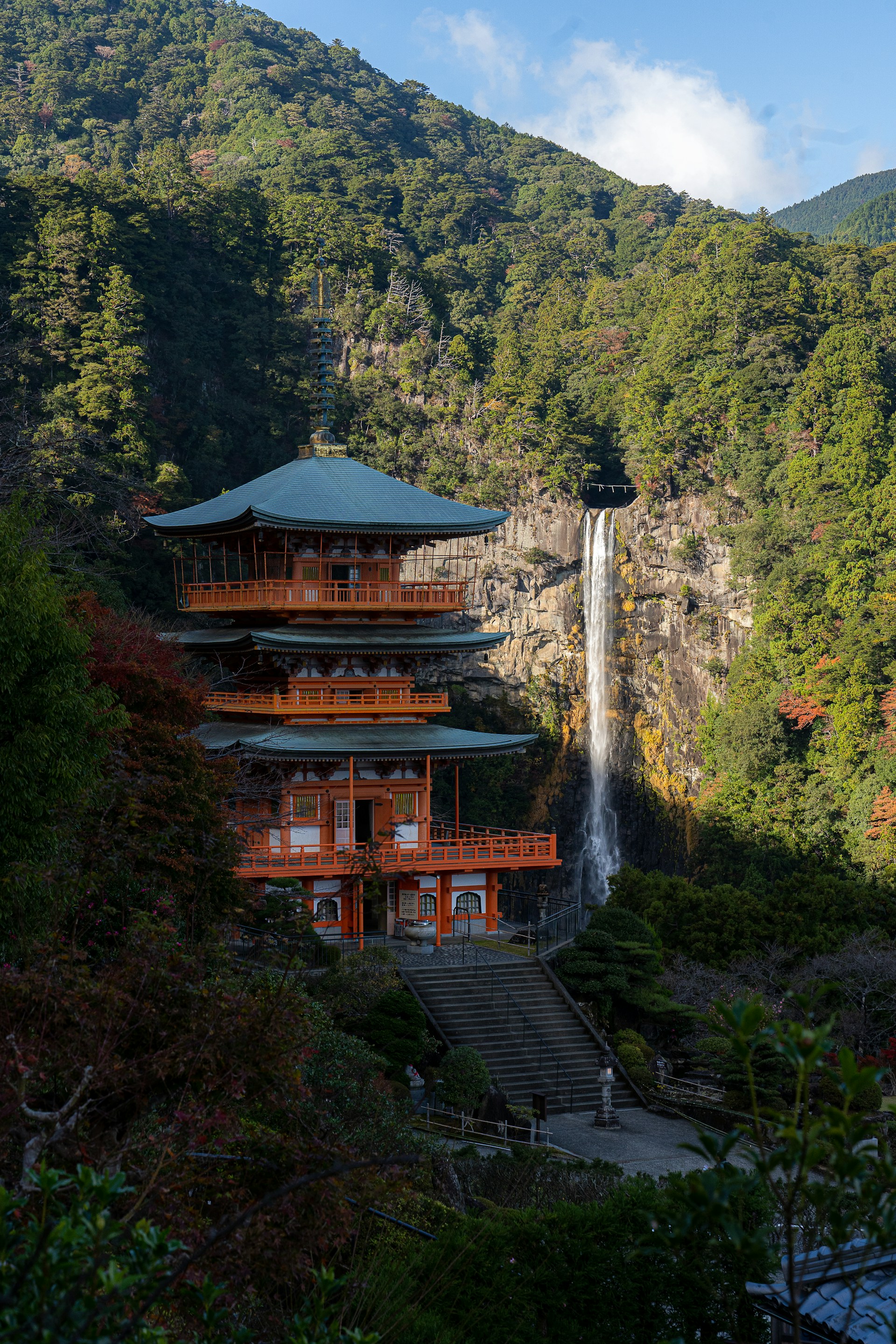 a building with a waterfall and trees around it