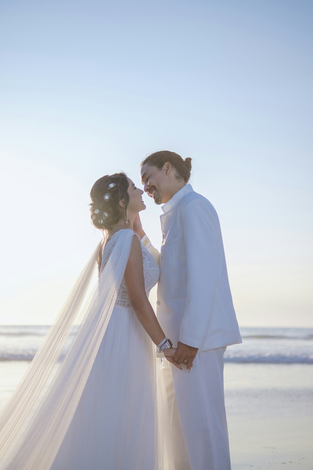 a man and woman kissing on a beach