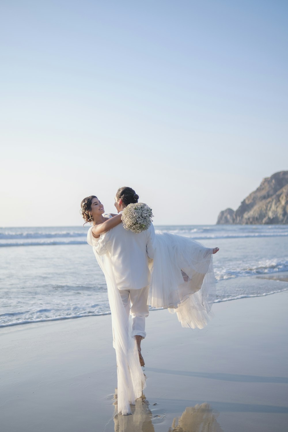 a man and woman holding hands on a beach