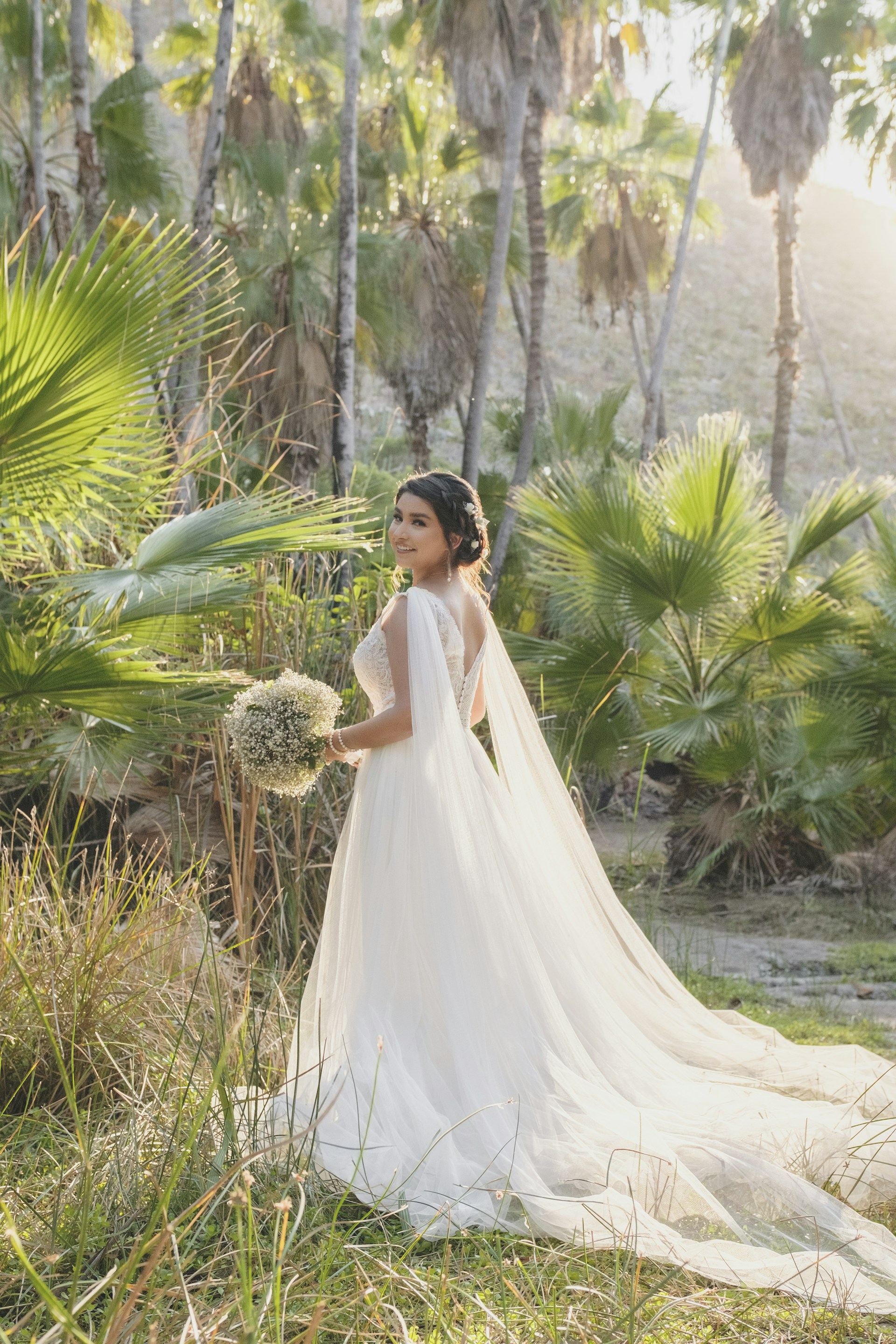 A radiant bride laughing joyfully in a sunlit garden, capturing the magic of a wedding day.