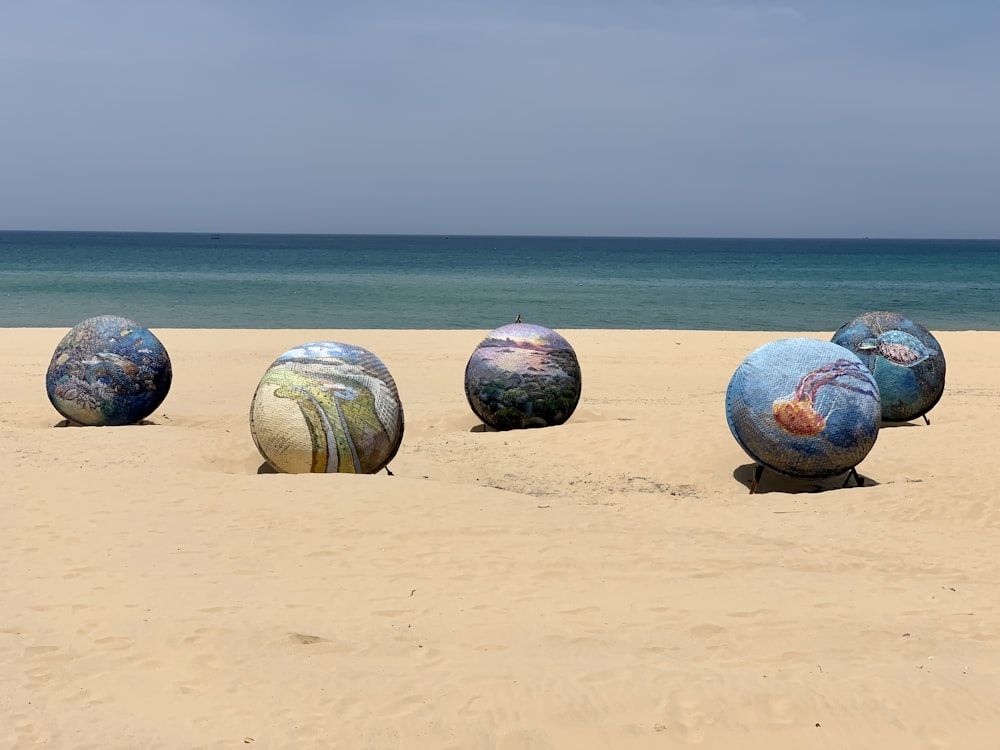 A group of colorful balls on a beach photo – Free Beach Image on