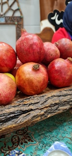 A close-up of pomegranates resting on a rustic wooden table.
