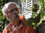 Adrián Martin inspecting plants with a focused and caring expression.