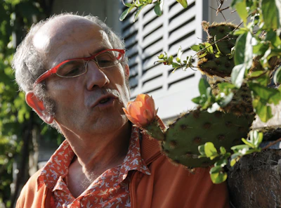 Adrián Martin inspecting plants with a focused and caring expression.