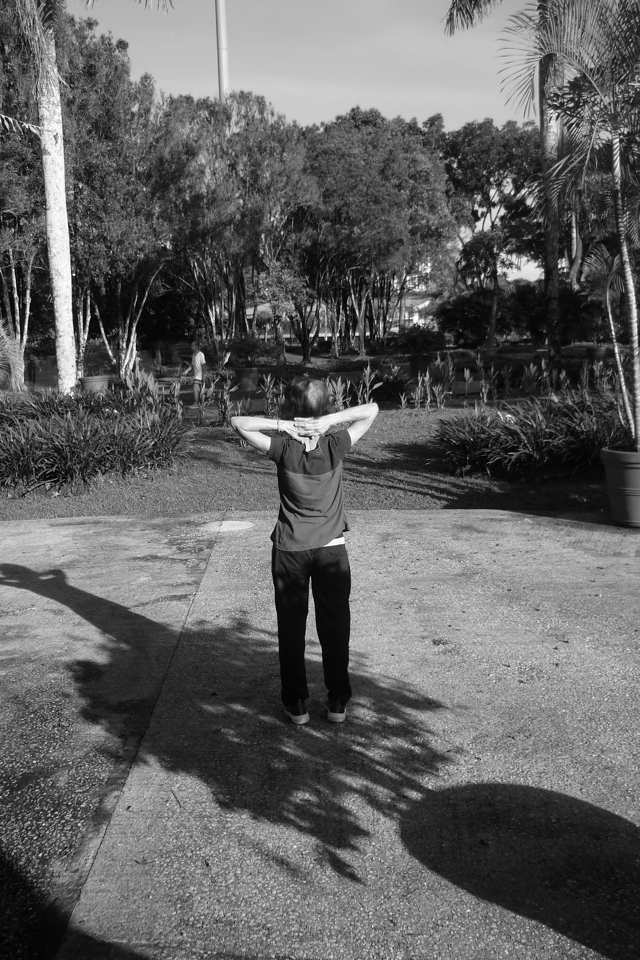 Person stretching outdoors after exercise, relaxed expression, natural outdoor setting