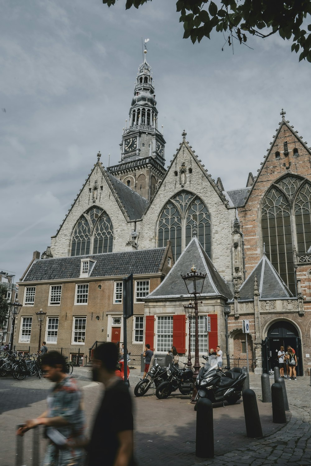 un grupo de personas de pie fuera de una iglesia con Oude Kerk en el fondo