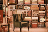 A cozy café corner with plush chairs, bookshelves filled with fantasy novels, and a window showing neon reflections.