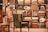 An elegant and cozy bookstore corner features a plush, green armchair set against a backdrop of neatly arranged bookshelves filled with colorful books and decorative plates. Soft lighting enhances the warm and inviting atmosphere.