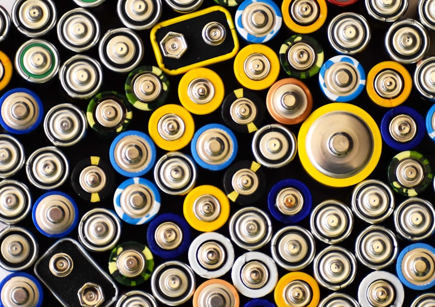 A close-up of a variety of car batteries displayed on a shelf in a well-lit store.