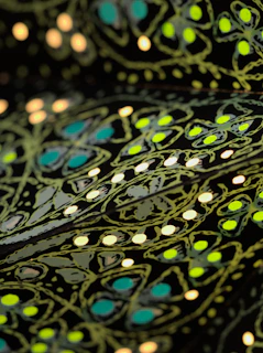 Close-up of a vivid tee featuring a neon geometric pattern that pops brilliantly on black fabric.