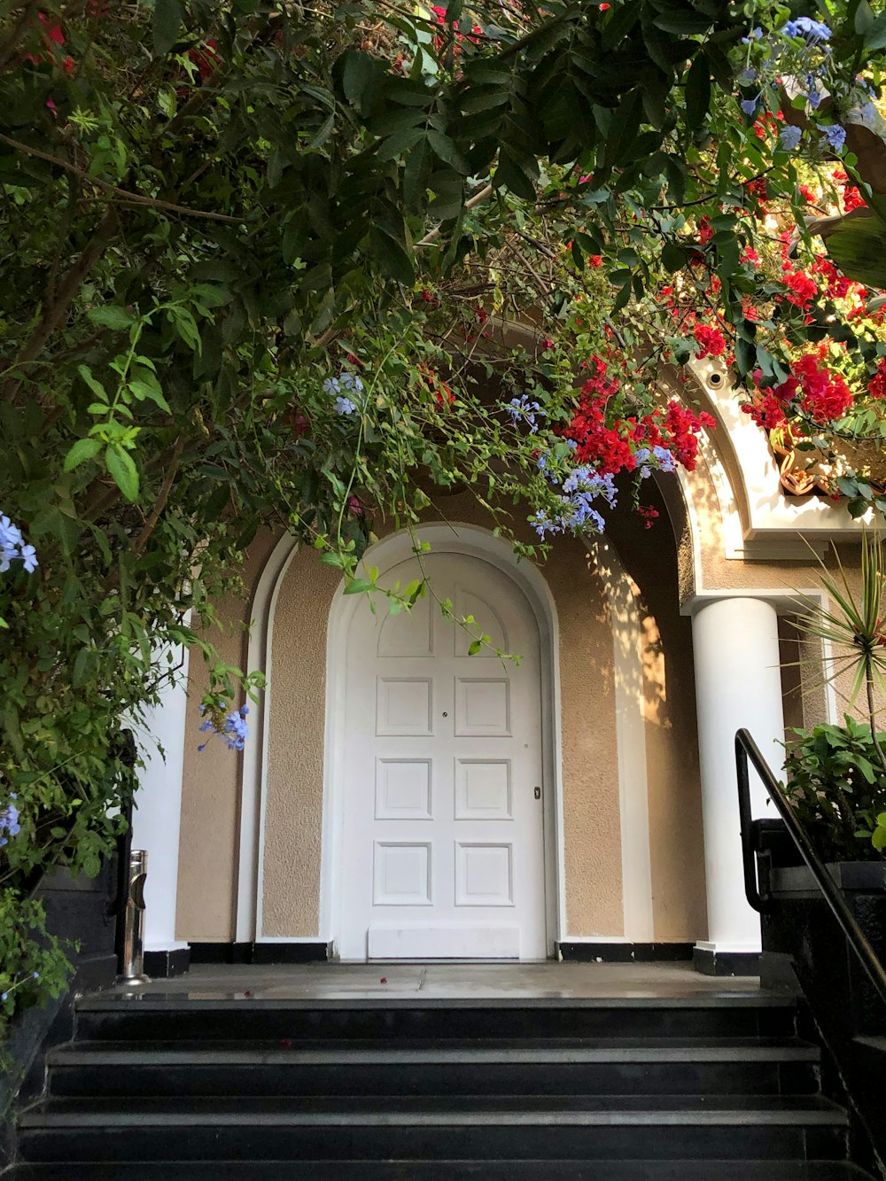 a white door with a white door and red flowers on the side