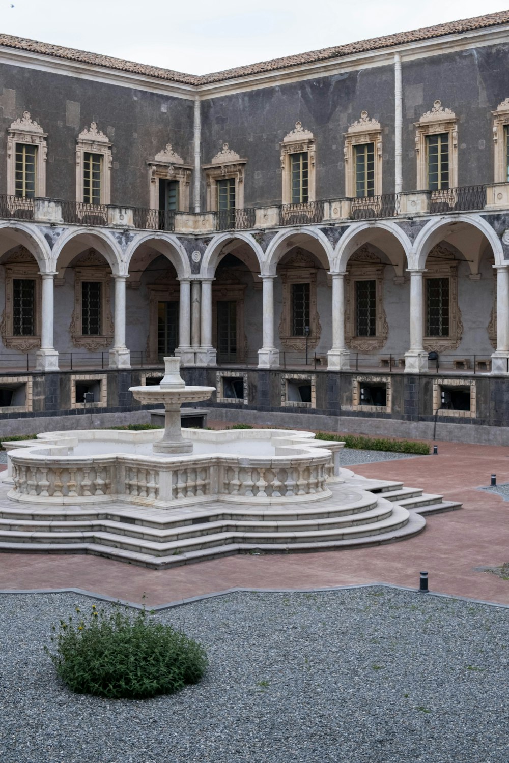 Un gran edificio con una fuente frente a él