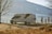 A couple exploring a beautiful landscape with their caravan parked nearby.