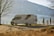 A couple exploring a beautiful landscape with their caravan parked nearby.