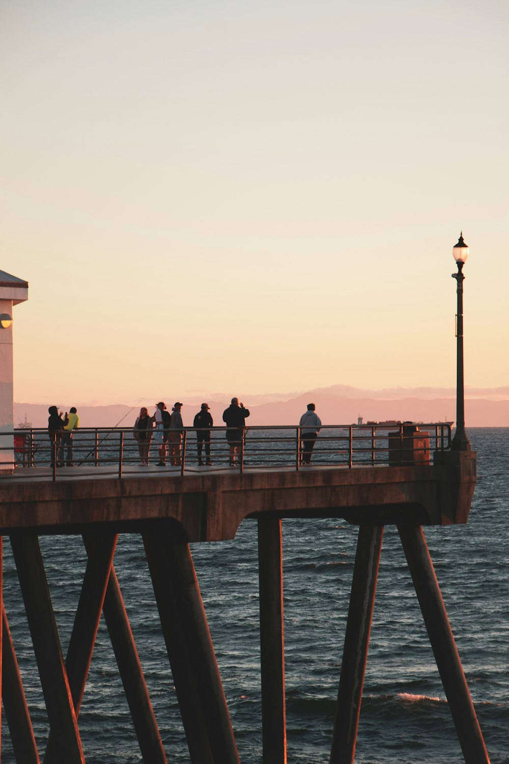 a group of people walking on a pier