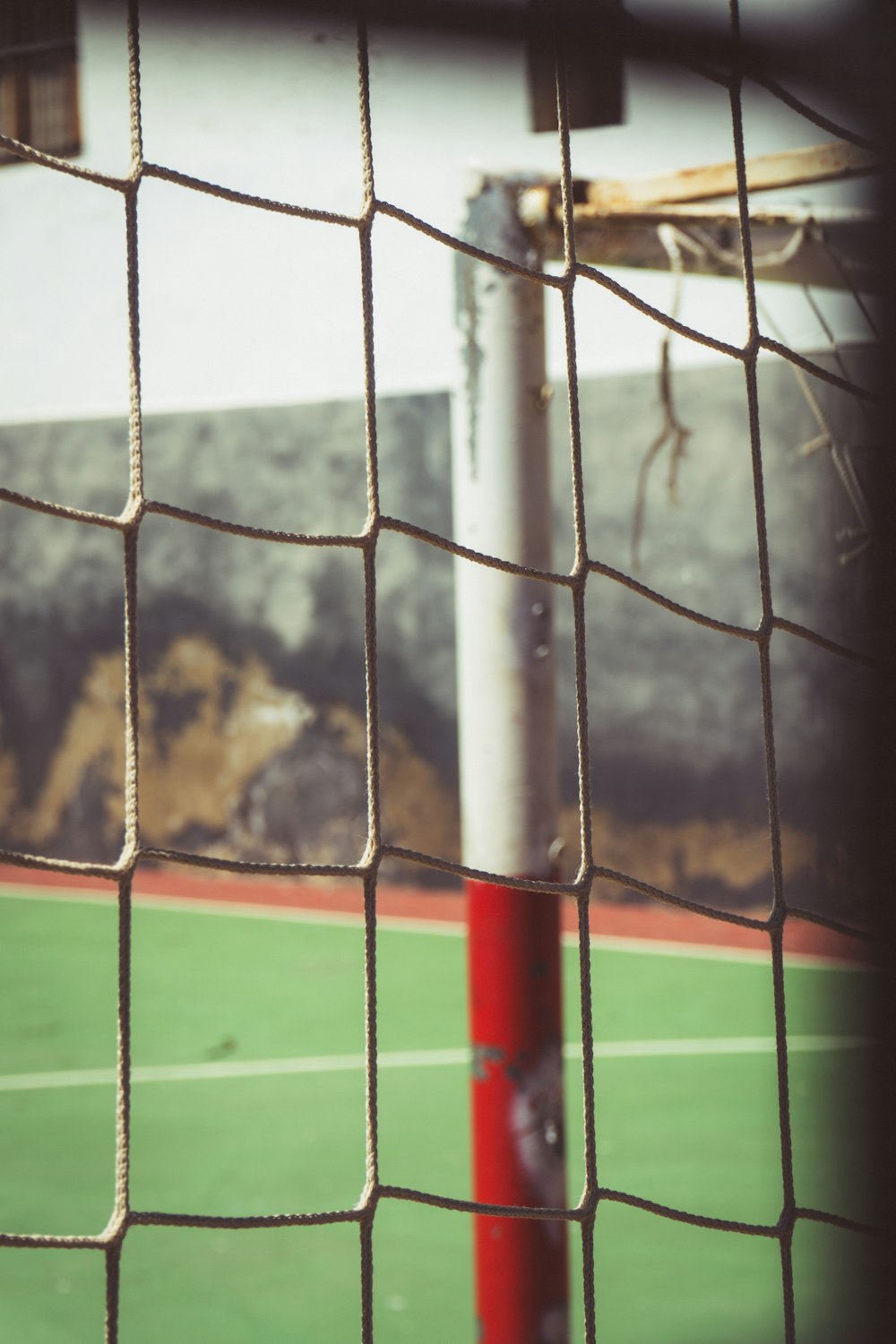 a red and white striped pole in front of a fence