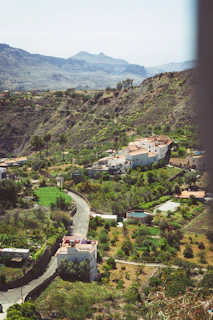 A serene countryside landscape with travelers admiring rolling hills and quaint villages.