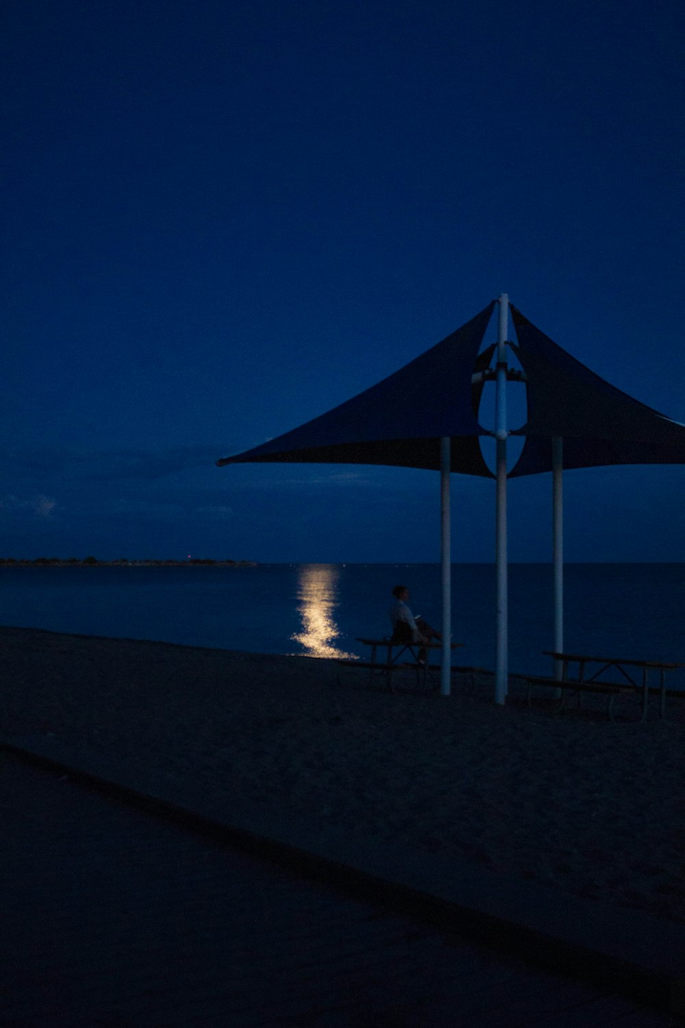 a person sitting on a bench next to a body of water