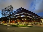 A modern hospital building illuminated at dusk, symbolizing growth and innovation.