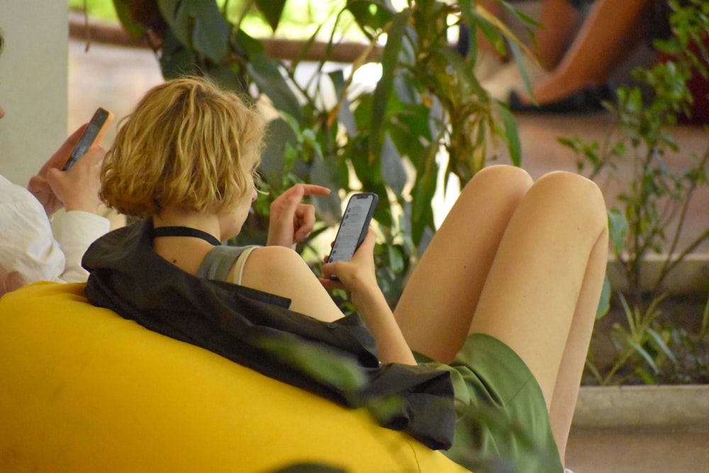 a woman sitting on a bench using her cell phone