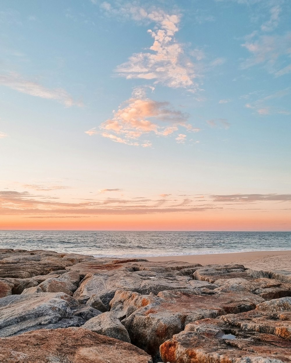 a rocky beach with a sunset