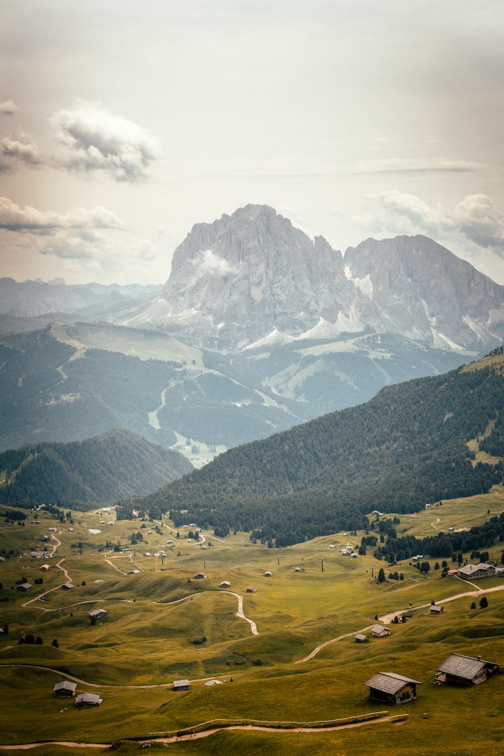 a valley with buildings and mountains in the background