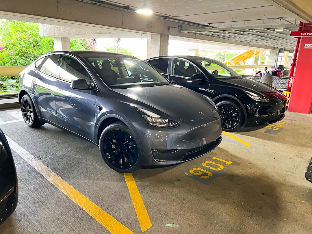 a couple of cars parked in a parking garage, Hertz Tesla pick up.